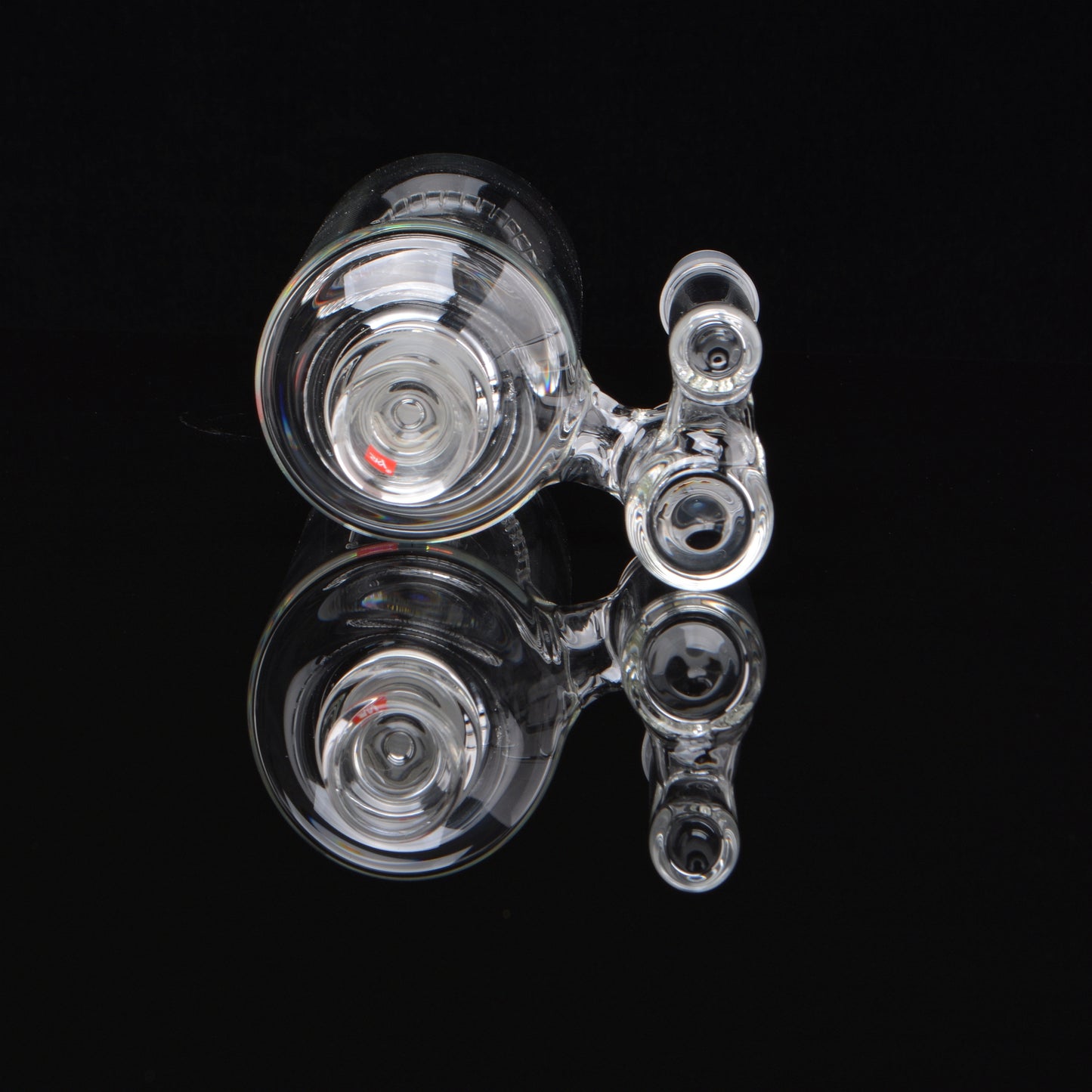 Splashcatcher for a bong laying on its side rotated 90 degrees on a black background