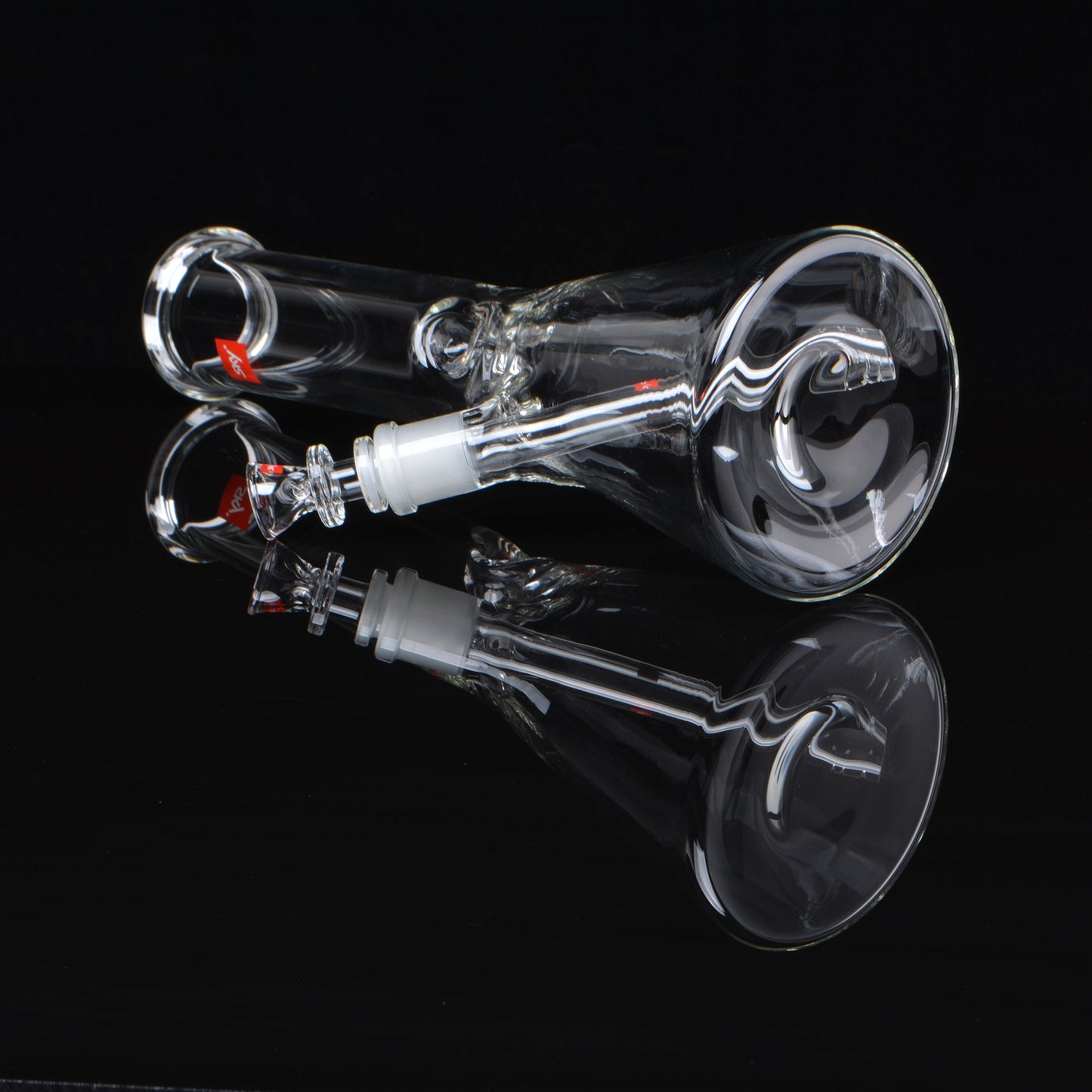 Beaker bong, clear glass, laying down, rotated 45 degrees