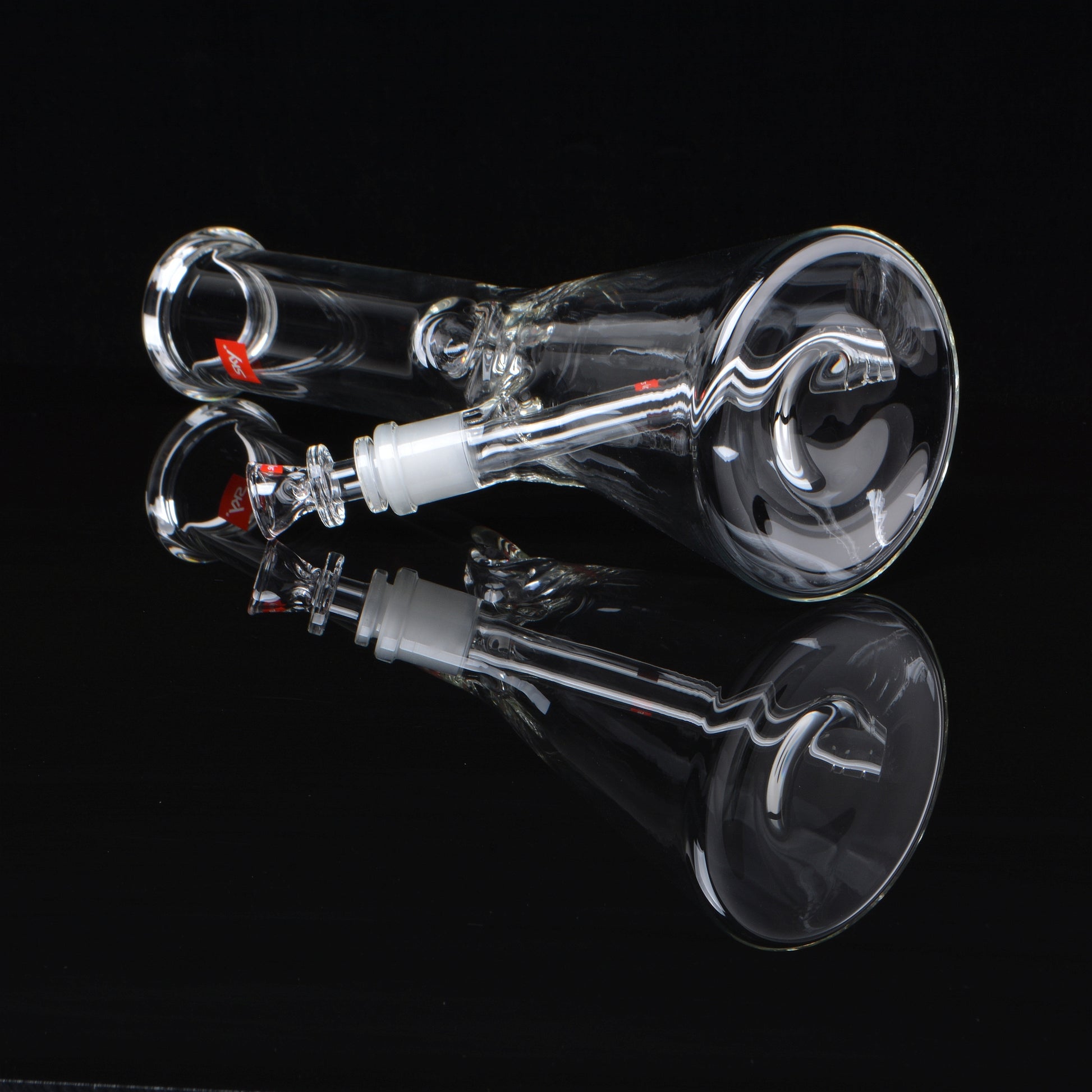 Beaker bong, clear glass, laying down, rotated 45 degrees